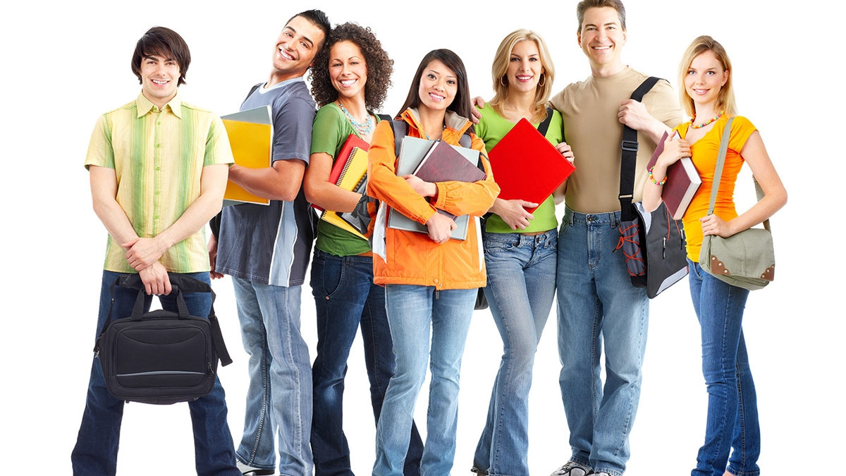 Students standing together holding books. smiling